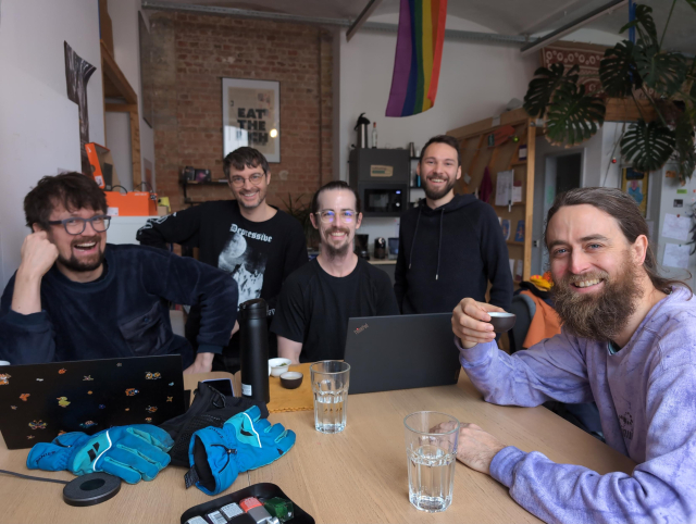 Hackers looking up from their work and posing for the camera in the Cultivation Space kitchen area.