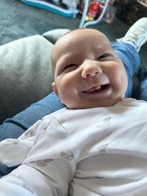 Bertie's got a huge smile on his face in this picture, wearing a long-sleeved outfit which could have birds or something on it.