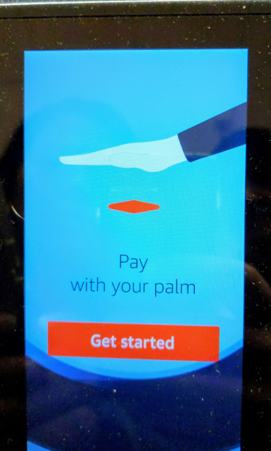 Photo of a payment terminal that indicates can pay by letting it photograph your palm and comparing it with a picture on file.