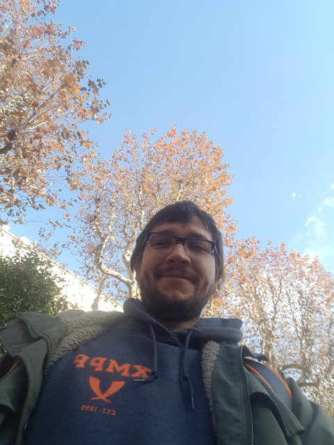 Selfie of myself, wearing the XMPP hoodie. Trees are autumny, sky is blue.