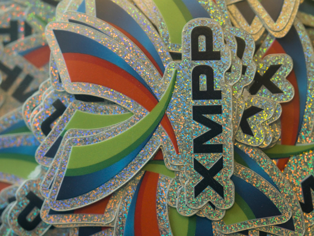 A pile of sparkly XMPP stickers, cut in the logo shape