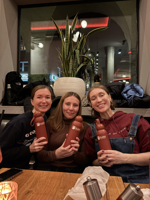 Tuta employees smiling while holding Tuta water bottles. 