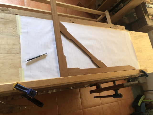 Sobre la superficie del zapatero, que funciona como mesa de dibujo, hay pegada una gran hoja de papel con masking tape. La reglota de madera está sujeta con sargentos, y sirve de referencia para la escuadra grande de madera. 