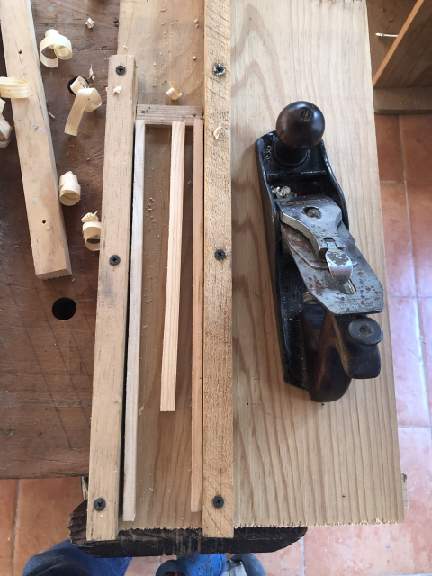 La guía para cepillar: una tabla, dos rieles, dos tiritas laterales con la altura correcta, y un tope para cepillar.