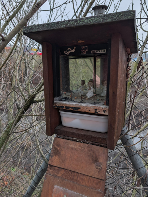 The cache masked as a bird box opened. There is something like a little angel fixture inside with a mirror behind it. Underneath there is a plastic box with a paper log and perks.