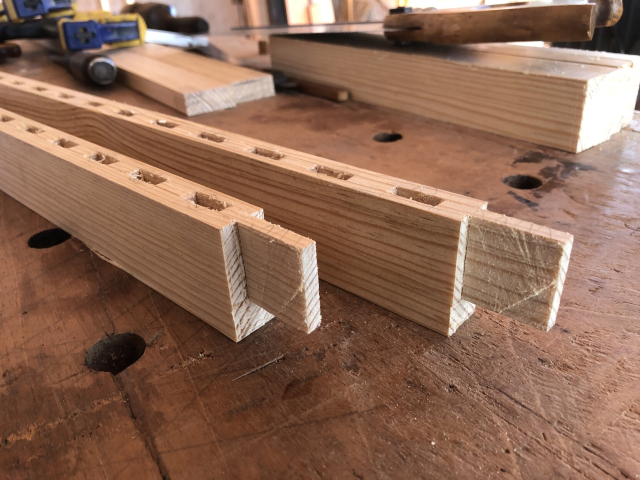 Dos piezas largas de las puertas, terminadas. Tienen las cajitas para las tiras y espigas en los extremos para ensamblar el marco de la puerta.