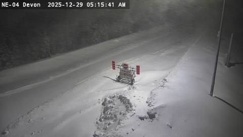 Highway 101 at 129 (Chapleau turnoff).  The roadway is clearly buried in heavy snow. In the middle of the frame sits the iconic "Emergency -- Road Closed" highway barrier.  A plow has cut a single lane path around it.