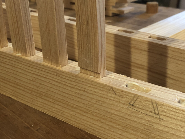 Tiritas de la rejilla que entran una por una, con pegamento, en sus respectivas cajas en las piezas horizontales de las puertas.