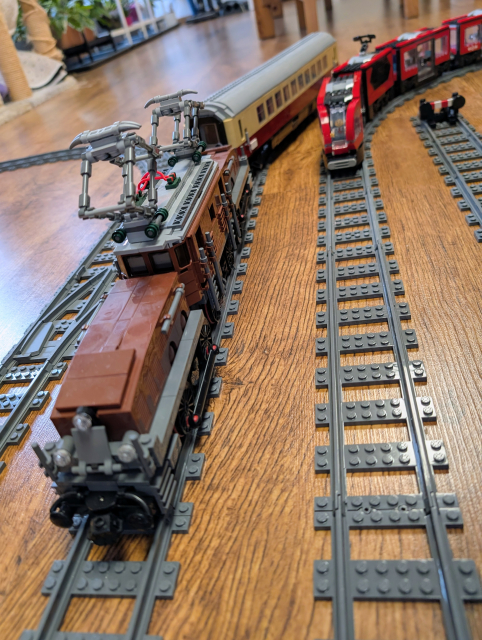 Picture of Lego Crocodile locomotive with passenger carriage from Bluebrixx, on the other track, there's Lego Downtown Tram.