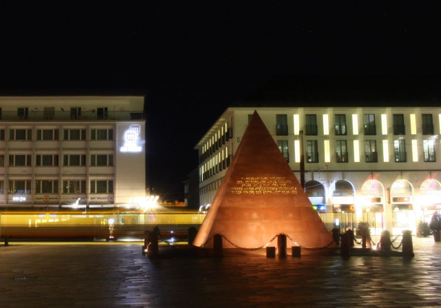Pyramide auf dem Marktplatz, dahinter fährt eine Tram vorbei