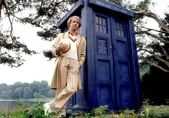 Peter Davison as the 5ht Doctor standing next to the TARDIS in  his debut Doctor Who story Castrovlava