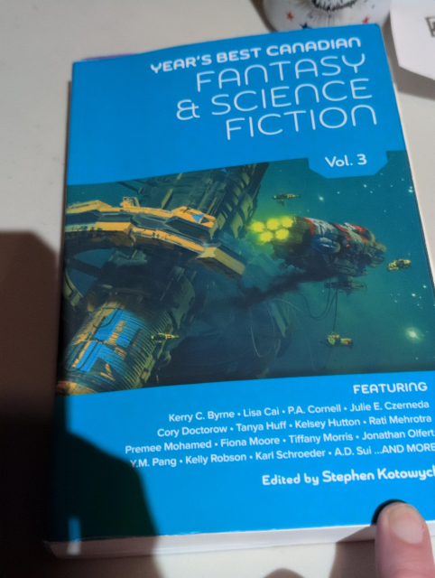 A blue book with a sea green space scene of a spaceship passing a space station. Year's Best Canadian Fantasy and Science Fiction Vol 3. Features a bunch of authors including @pluralistic and edited by Stephen Kotowych