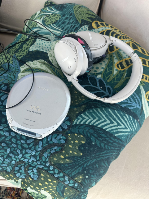 Modern Bose headphones next to an early 2000s Sony CD Walkman.