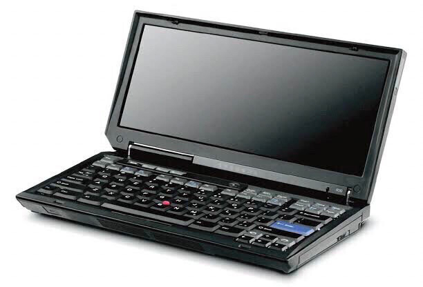 A photo of a small early 21st century laptop, a thinkpad, with full sized keyboard but no trackpad space and a short wide screen like a large beautiful PDA with early thinkpad styling. It is small and if it doesn’t love you almost certainly has a little bit of a crush on you. 