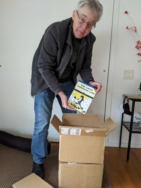 A photo of yours truly opening a box of newly printed copies of my book fresh from No Starch Press.