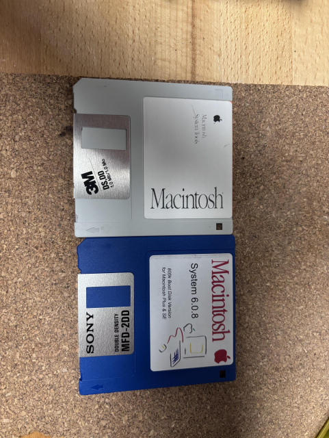 Picture of two 800k boot floppies for Mac OS 6.0.8 ... one blue, one cream coloured