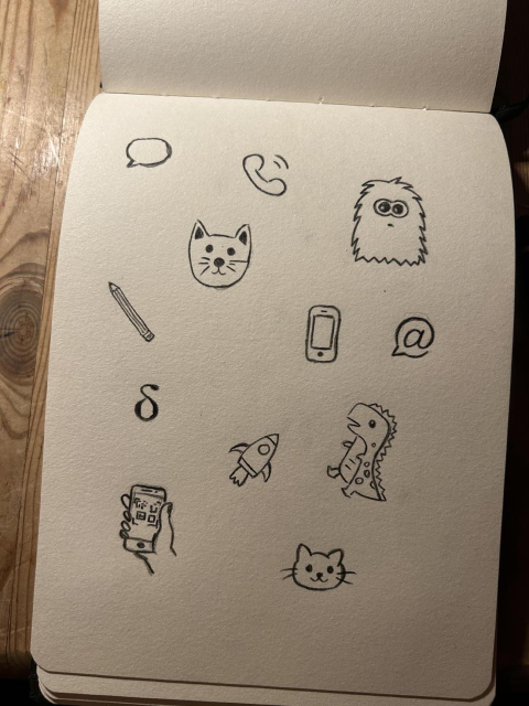 sketchbook with handdrawn deltachat logo, chatmail logo, rocket, phones, message bubble, monster, cats and dino