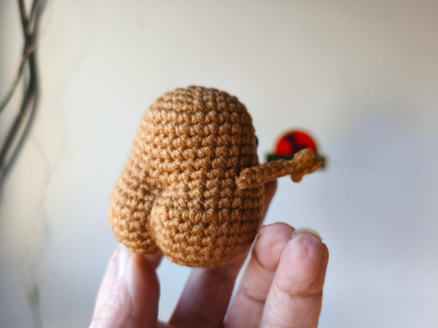 La misma patata tejida mostrando su redondeado culo esponjoso desde otro ángulo