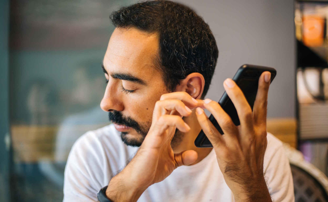 Photo of a blind person using a smartphone with a screen reader