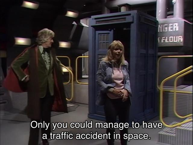 Jon Pertwee episode. The Doctor and Jo are standing in front of the TARDIS, one door open, materialized onto a spaceship in the future, and you can tell, because every surface is metal, the walls are an odd non-square shape, there are weird lights on the walls, and a big pipe labeled “FLOUR” in a futurey computery font instead of a normal one. Unlike that other popular science fiction franchise, there are plenty of handrails and guard rails on the stairs and ledges, even painted in bright industrial yellow. The Doctor is posing Doctorally while Jo says, “Only you could manage to have a traffic accident in space.”
