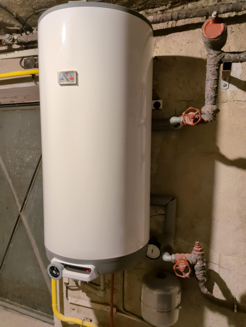 Bojler s přítokem a odtokem vody z/do radiátorů.