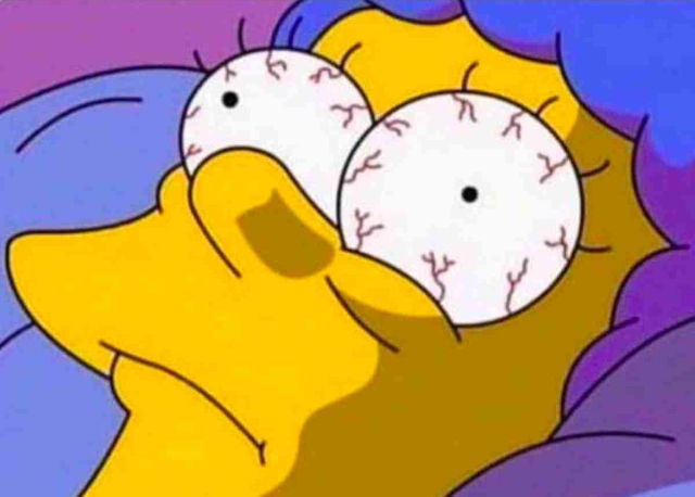 woman in bed with big opened eyes 