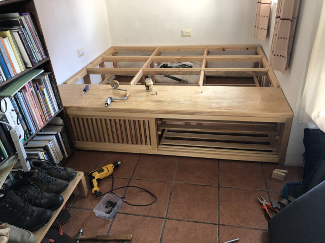 El zapatero puesto en su lugar, al frente de la tarima. Hay herramientas en el suelo para poder fijar el zapatero y que no se mueva.