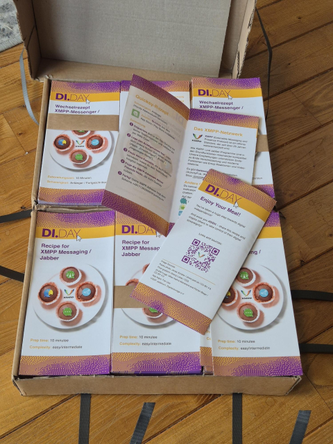 Two cartons full of printed folded flyers in white, orange and magenta, with XMPP migration recipes