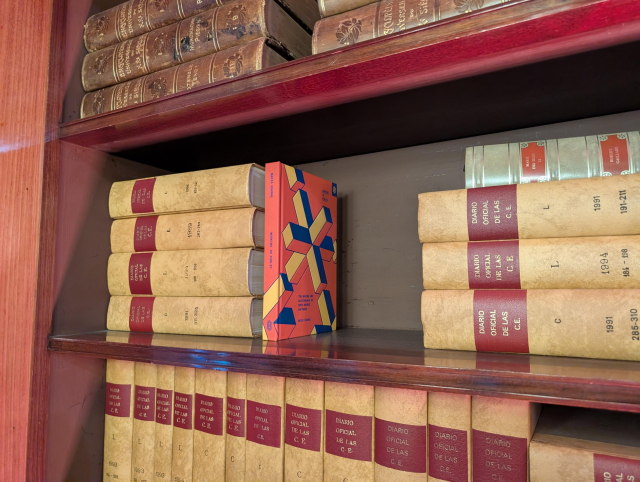 The book working in public on a shelf next to old books 