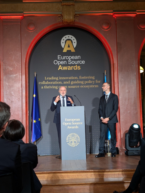 Roberto and Zach at a podium on sage at the Awards