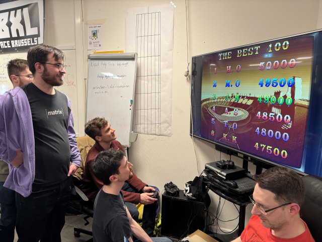 People are playing a retro game on a wide flat tv screen.