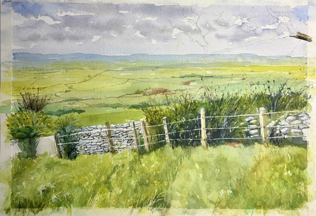 A watercolor landscape depicting rolling green fields under a cloudy sky. A stone wall and wooden fence in the foreground are surrounded by tall grass and shrubbery.