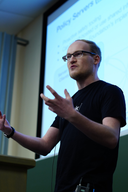 A close up portrait of Travis, a man giving a talk in the Decentralised Communication devroom at FOSDEM