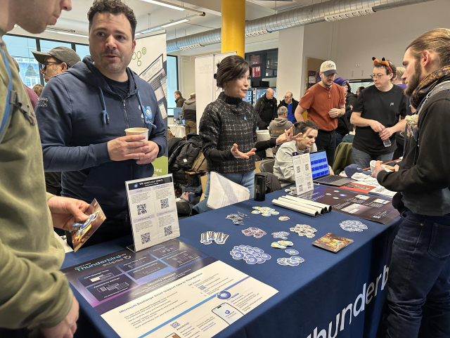 Wolf and Natalie talking to visitors to the Thunderbird stand at FOSDEM