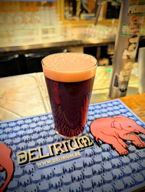 very dark red beer on a Delirium bar mat