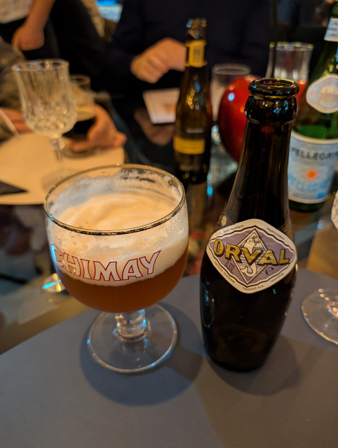 glass of beer next to am Orval beer bottle