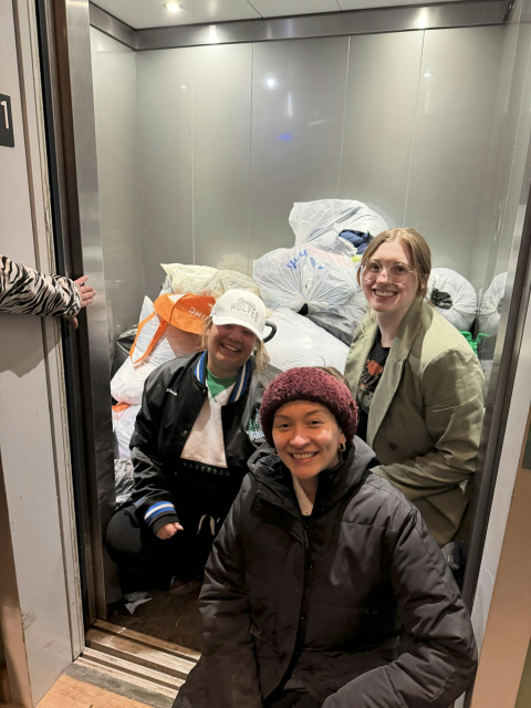Smiling volunteers pose at the open doors of an elevator filled with bags of donated winter clothing.

Caption: Donated coats warm the heart (and the rest of the body), but mutual aid groups say monetary donations are even more useful right now. You don't need a warehouse to store a cash donation. Photo courtesy of Sade Young.