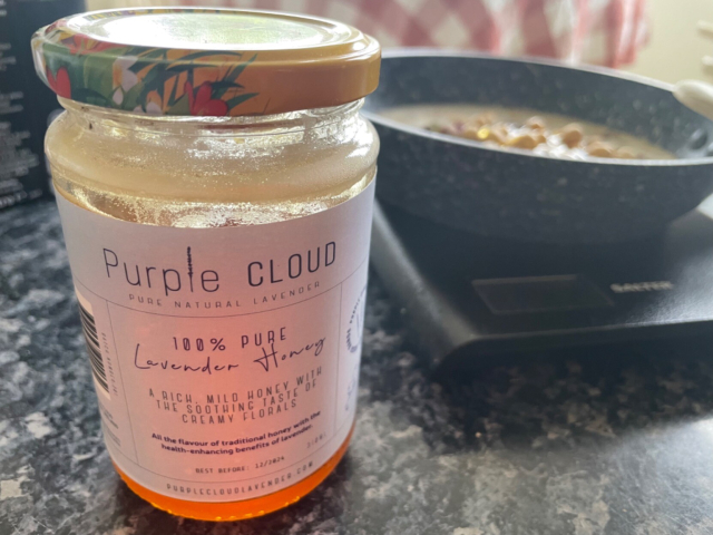 Bottle of the honey mentioned in the post. A small pan with porridge is in the background on a small digital kitchen scale.